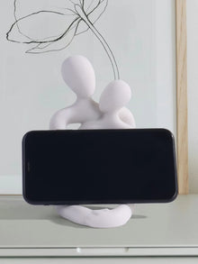 Escultura pareja abrazada porta celular