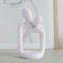 Escultura pareja abrazada porta celular