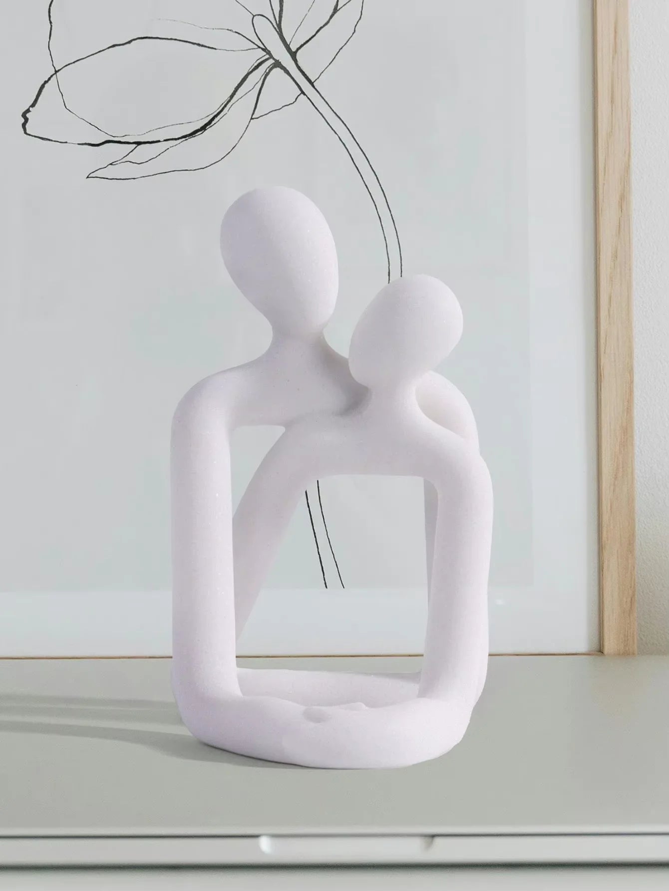 Escultura pareja abrazada porta celular